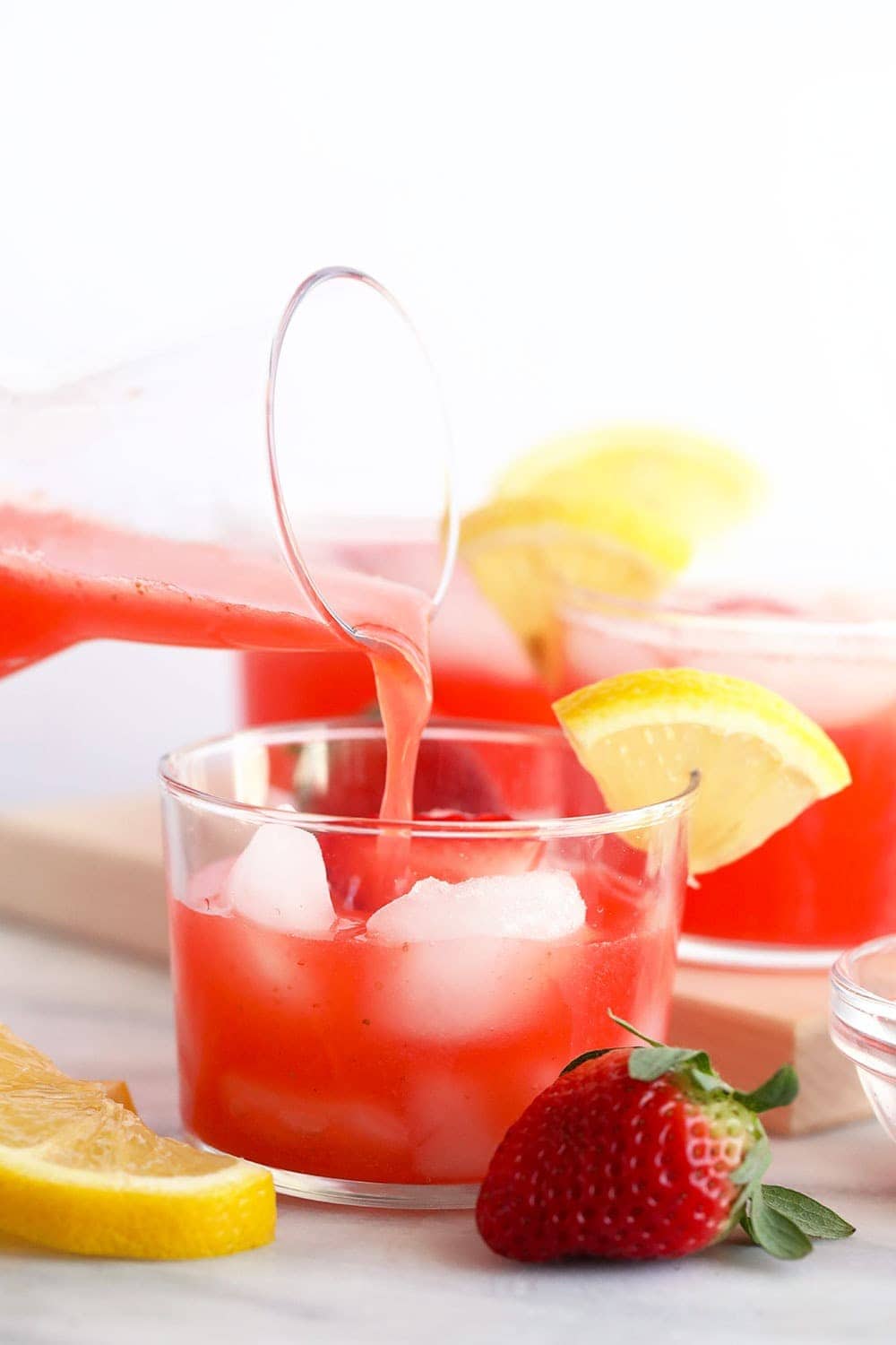 strawberry vodka lemonade being poured in a glass