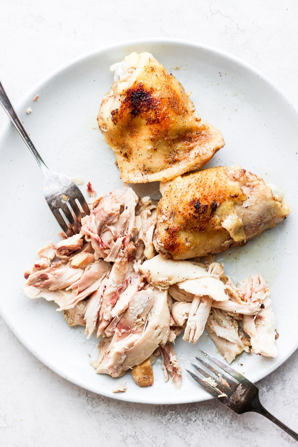 chicken thighs being shredded for chicken tacos