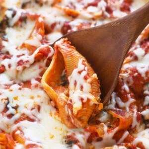 A wooden spoon is being used to scoop up a stuffed pizza.