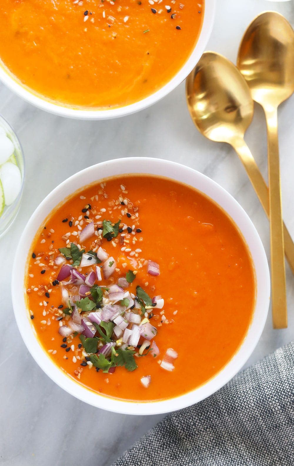 instant pot sweet potato carrot ginger soup in a bowl topped with diced onion