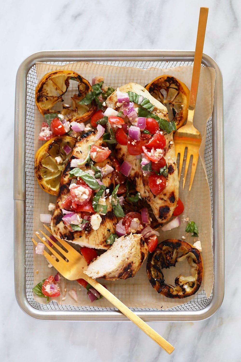 Grilled lemon chicken with Greek salad in a basket. 