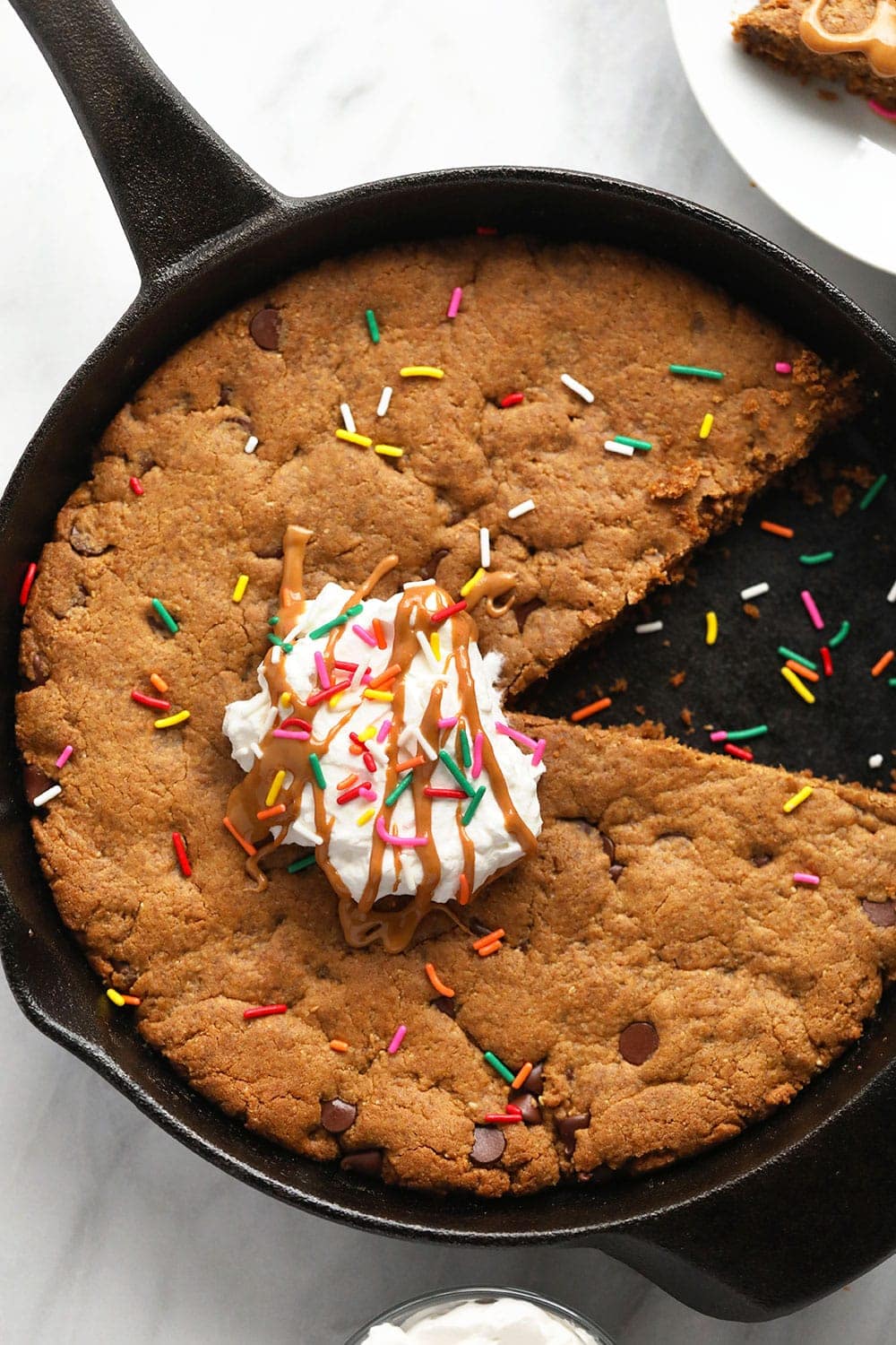 peanut butter skillet cookie topped with whipped cream and sprinkles