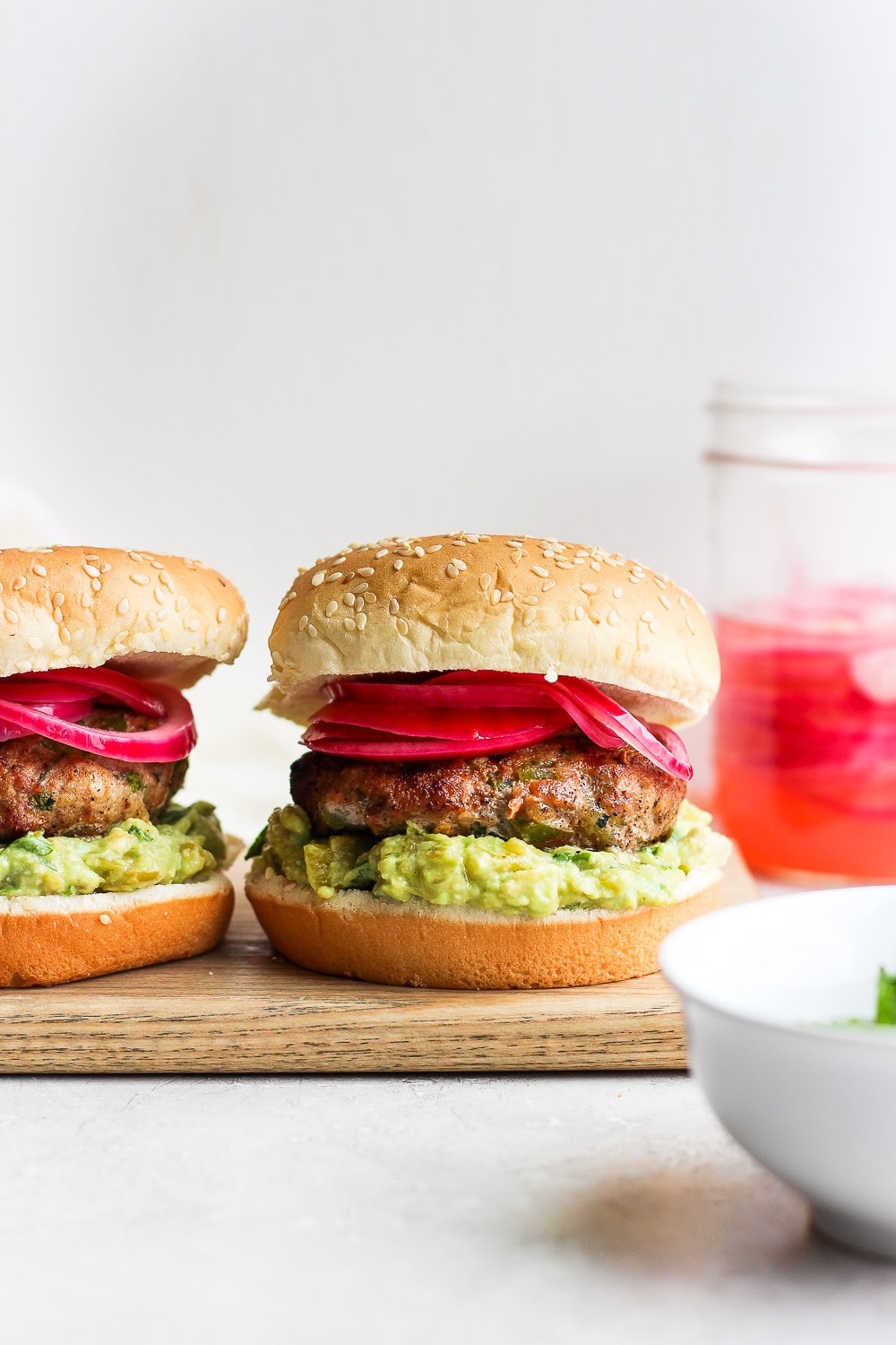 turkey burgers with pickled onions and avocado mash ready to be served.