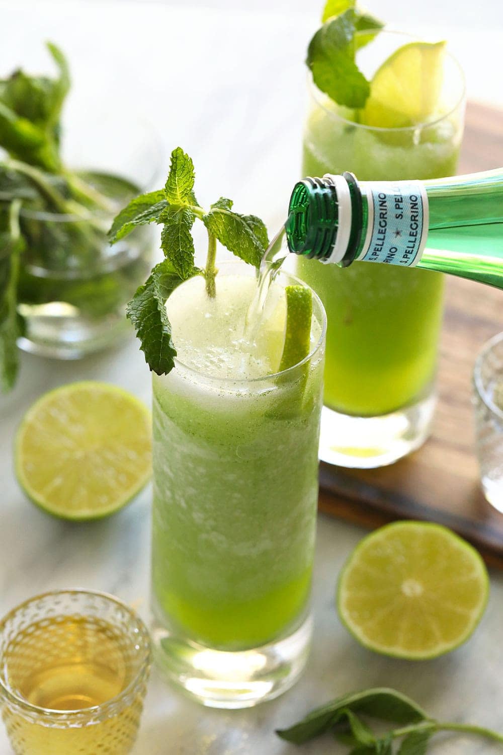 pouring sparkling water into frozen mojito