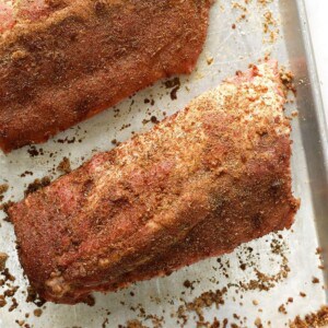 Two seasoned sous vide ribs on a baking sheet before cooking.