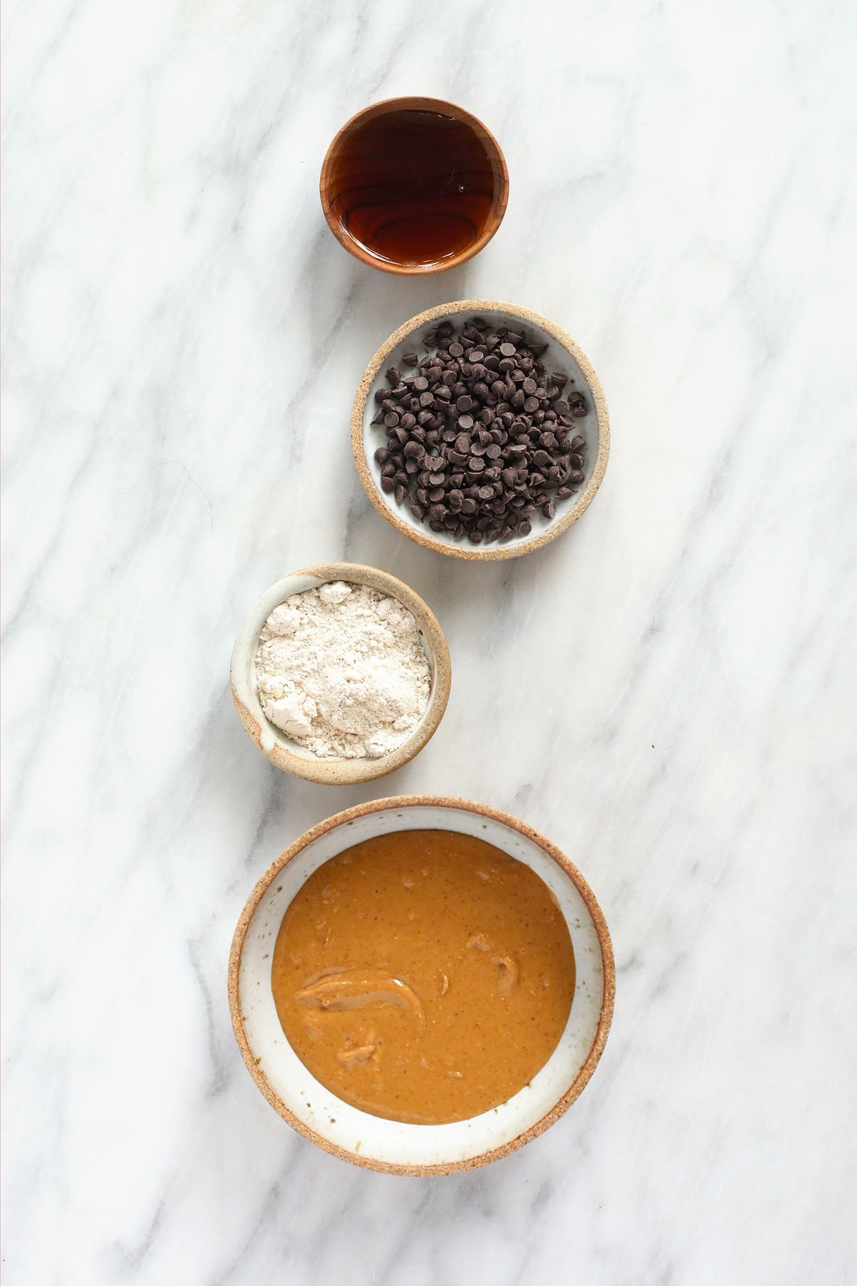 maple syrup, chocolate chips, oat flour, and peanut butter in bowls