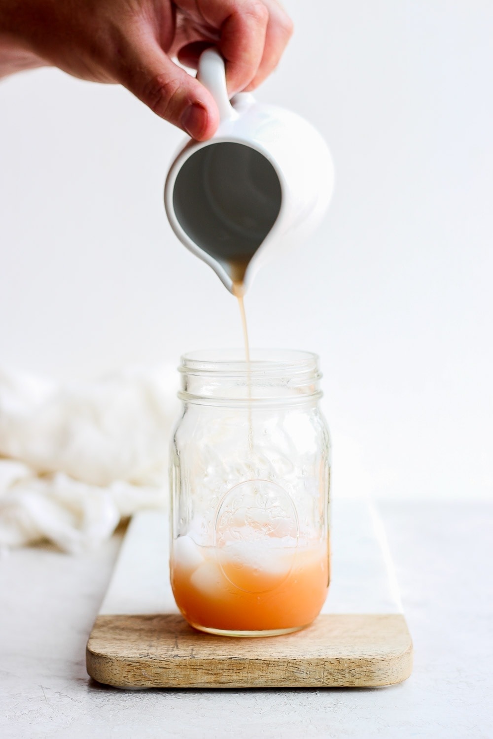 grapefruit juice for paloma cocktail being poured into a mason jar before being shaken to perfection