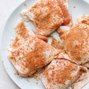 seasoned chicken thighs on plate.