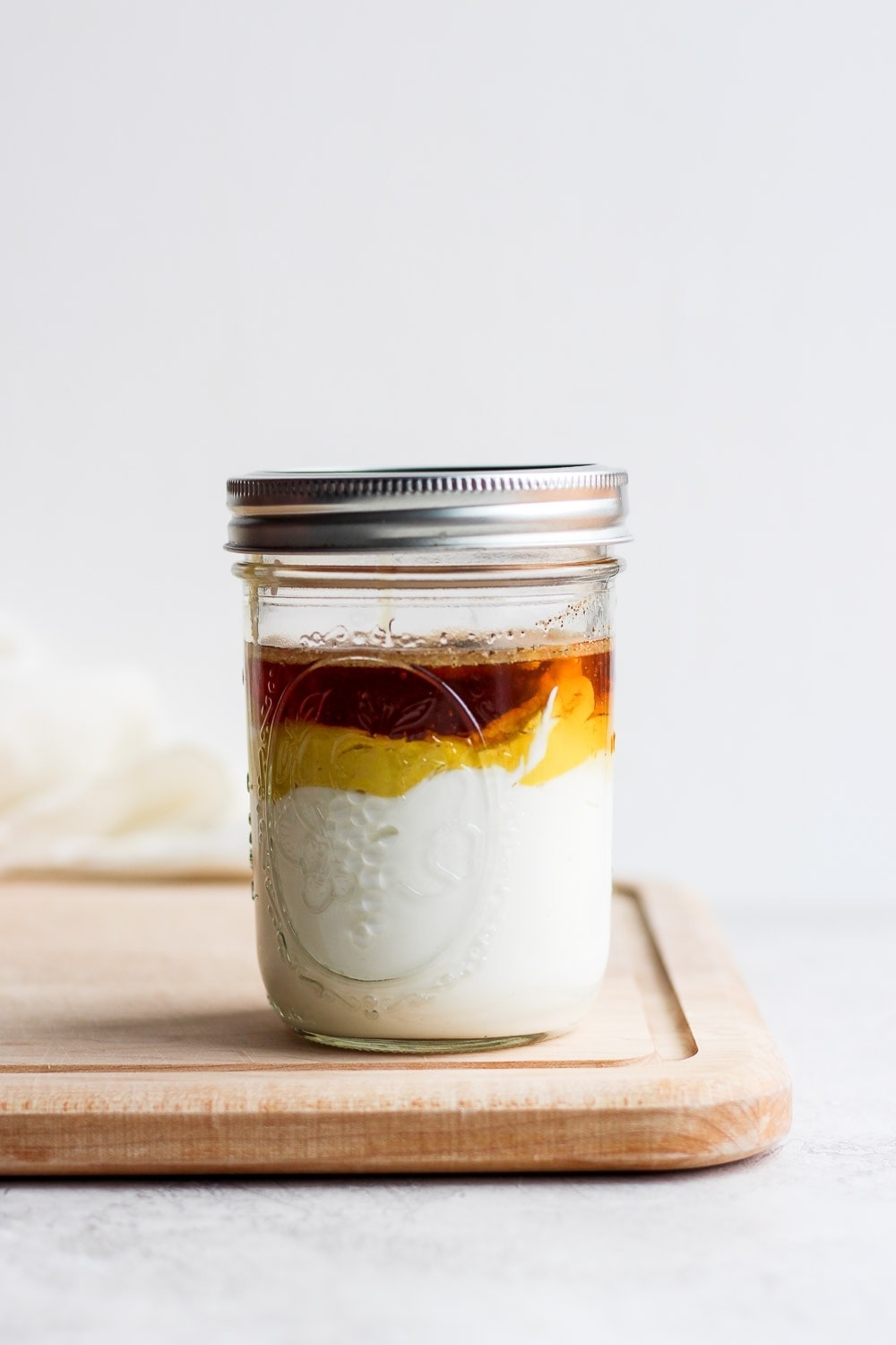 ingredients stacked in a mason jar on a cutting board