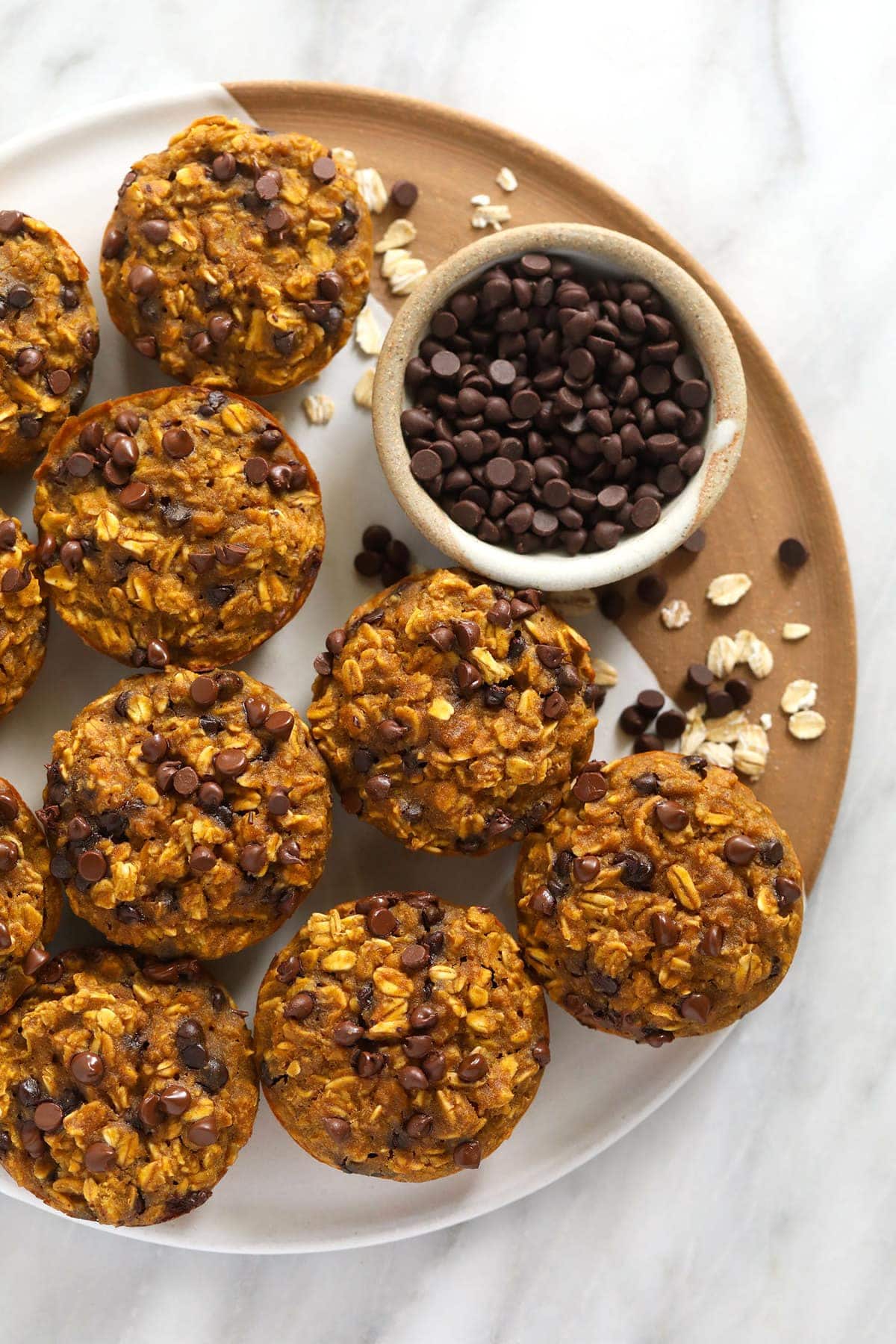 Pumpkin oatmeal cups on a tray with mini chocolate chips. 