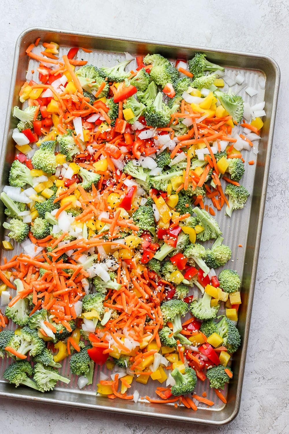 veggies for sheet pan salmon stir fry ready to be roasted in the oven