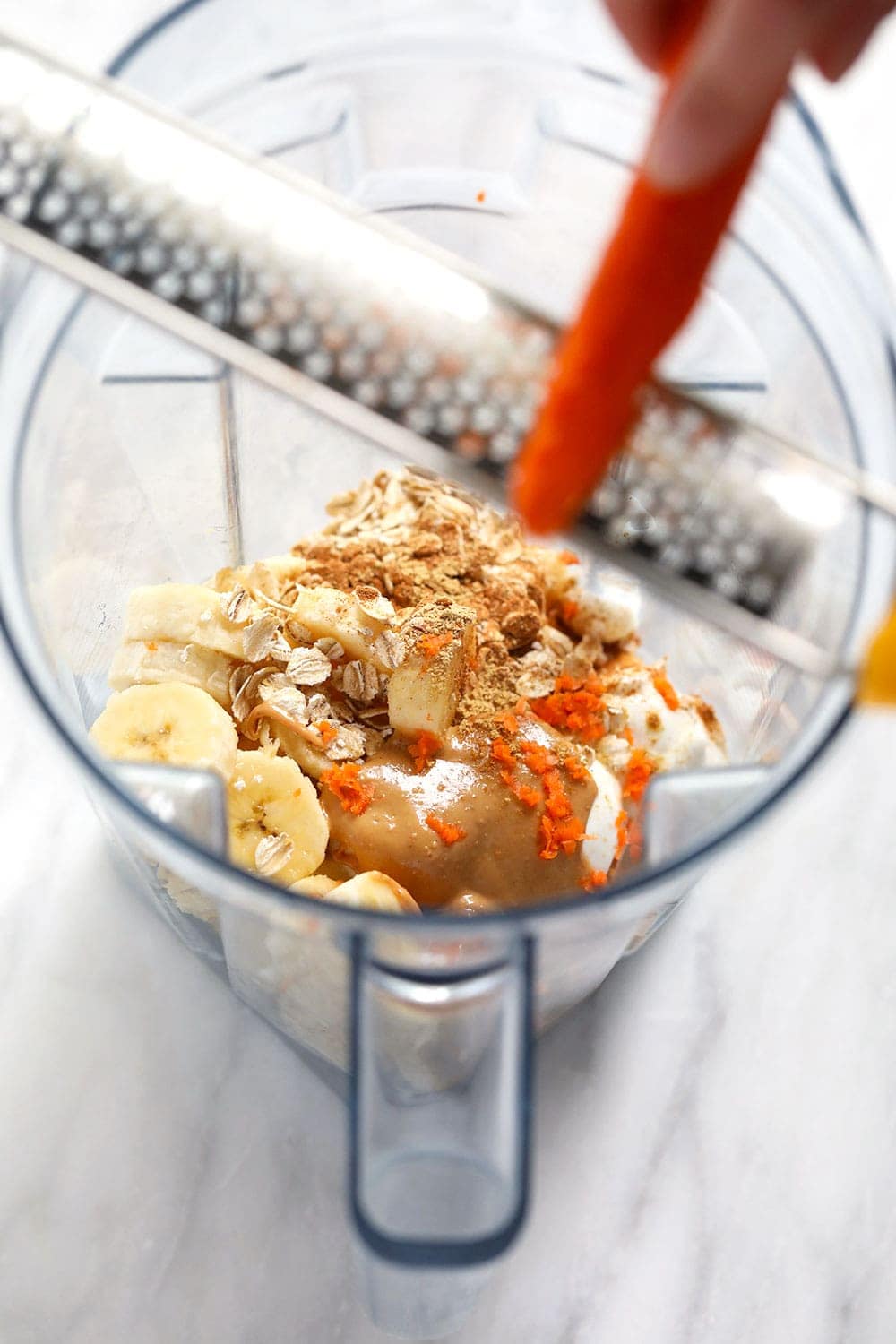 All the ingredients for a carrot cake smoothie in a vitamix. 