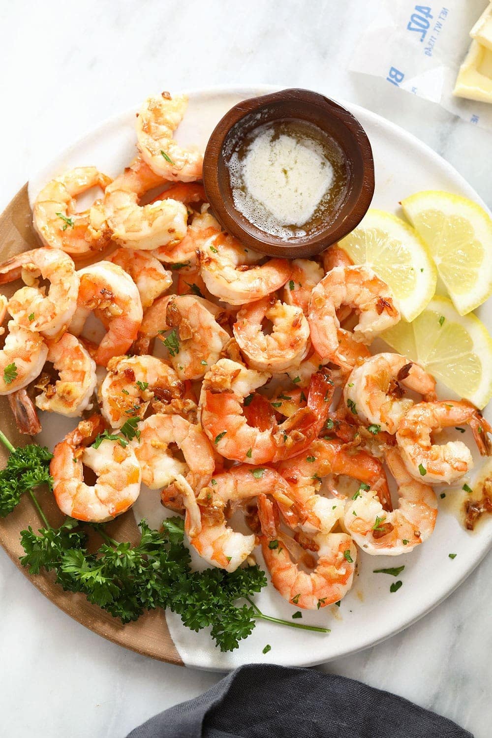 garlic butter shrimp on a plate with butter for dipping