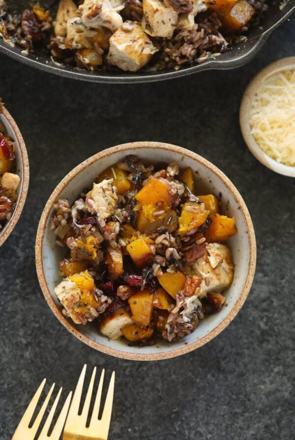 Two bowls of chicken and butternut squash casserole with cheese.