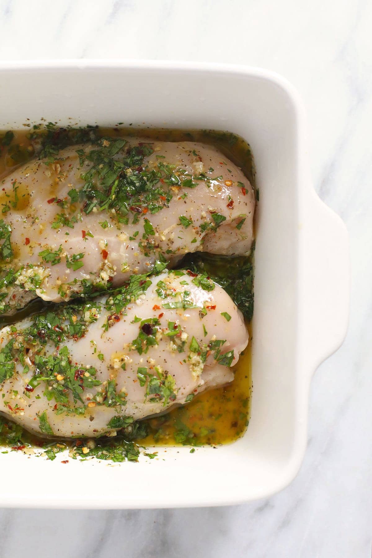 chicken marinating in dish.