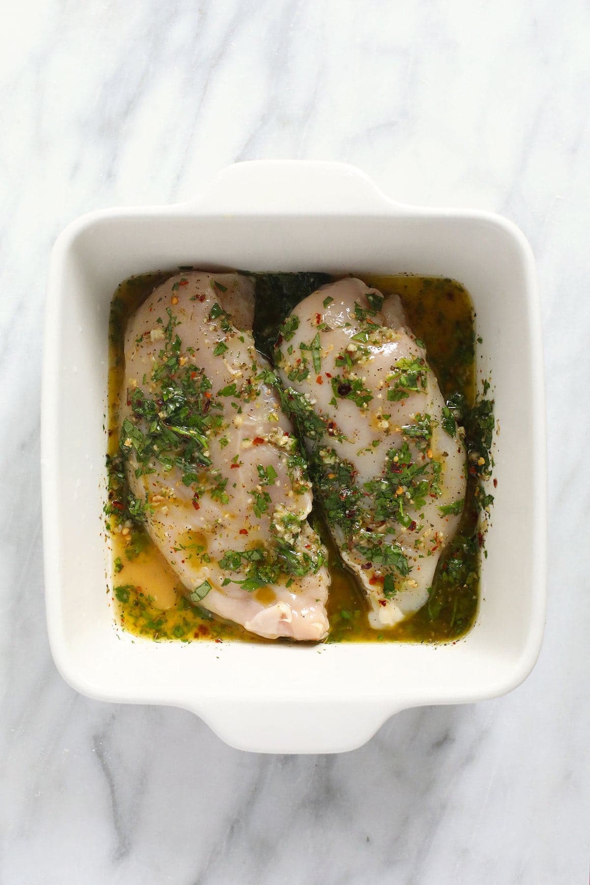 chicken marinating in dish.