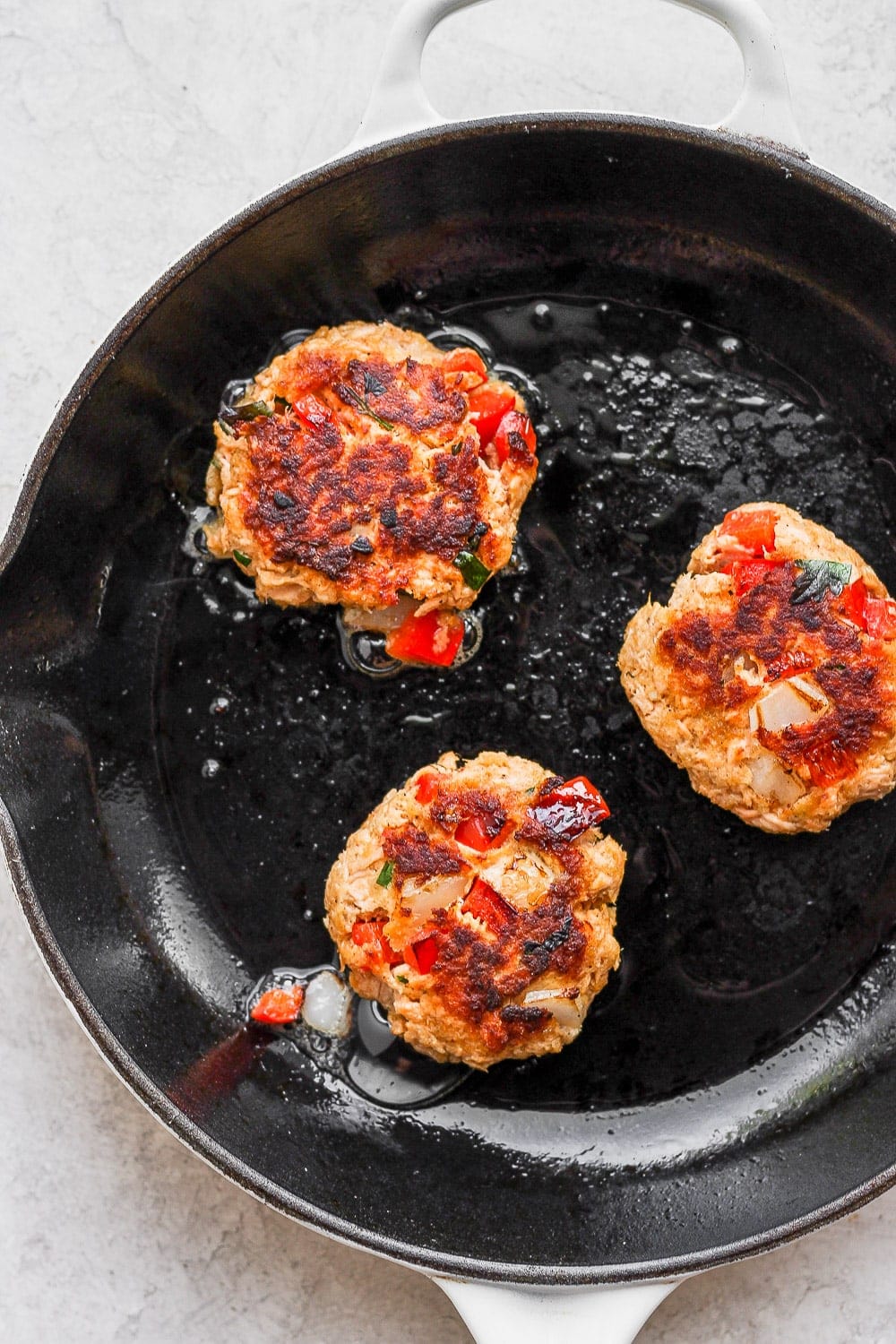 salmon patties pan frying in a skillet