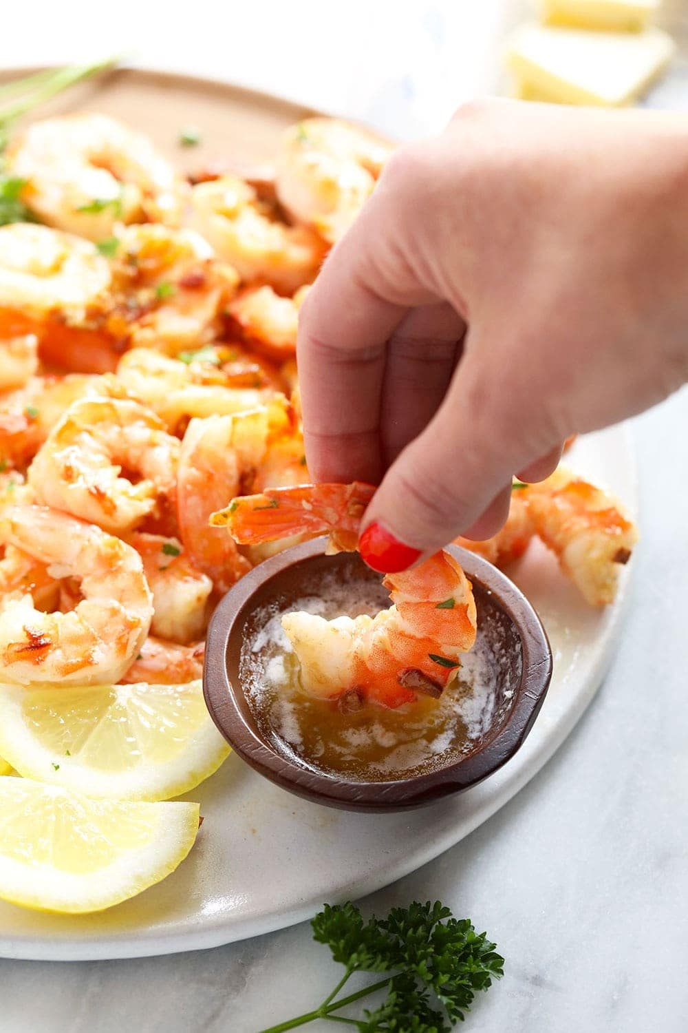 garlic butter shrimp being dipped in butter