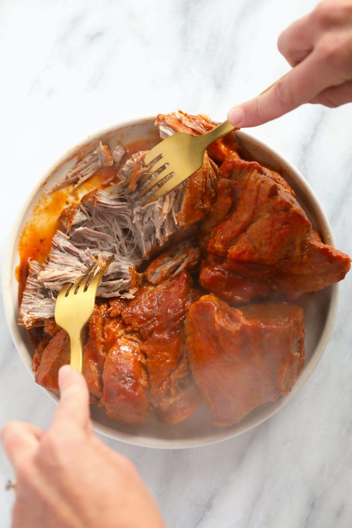 shredding pork with 2 forks.