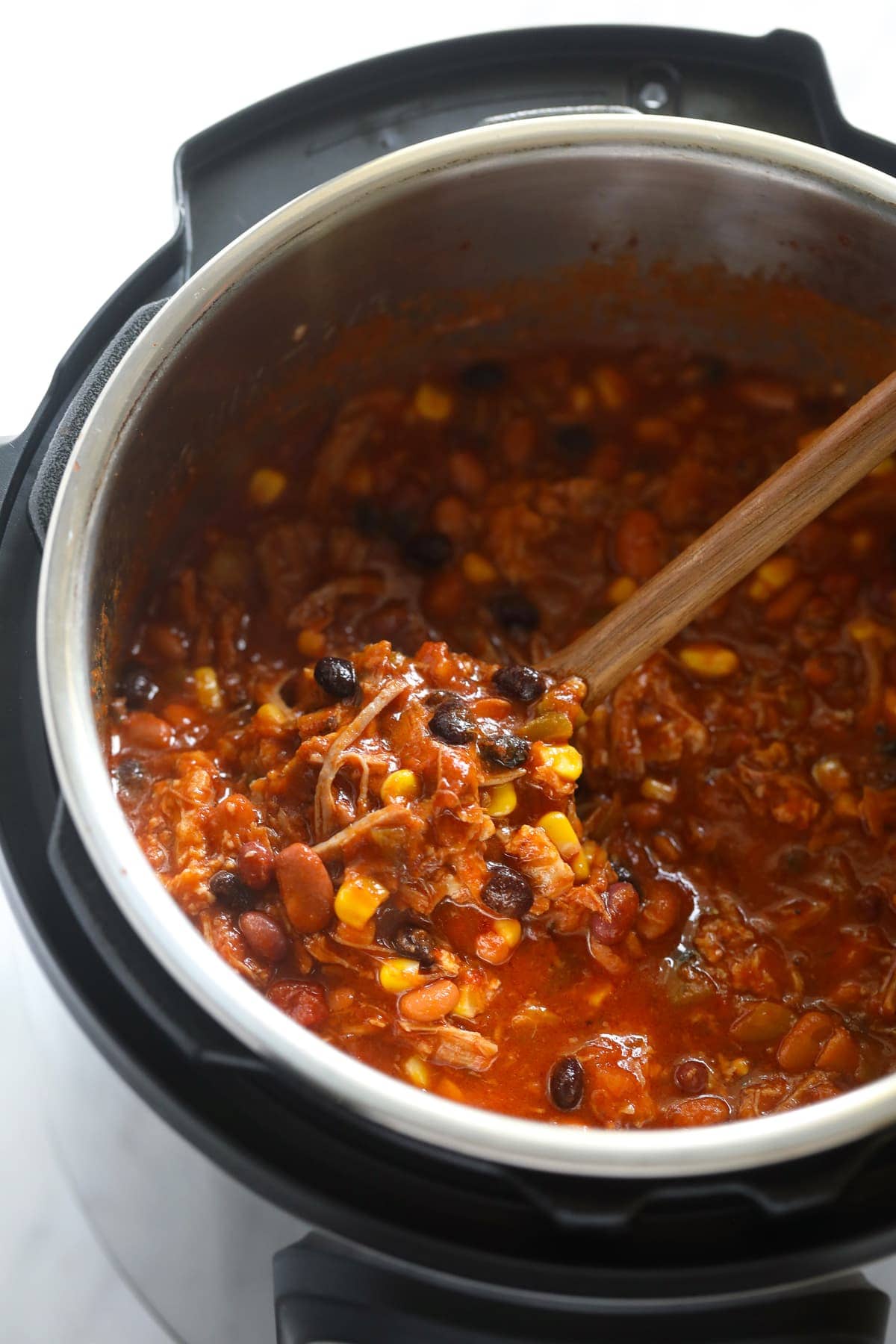 pulled pork chili in instant pot with spoon.