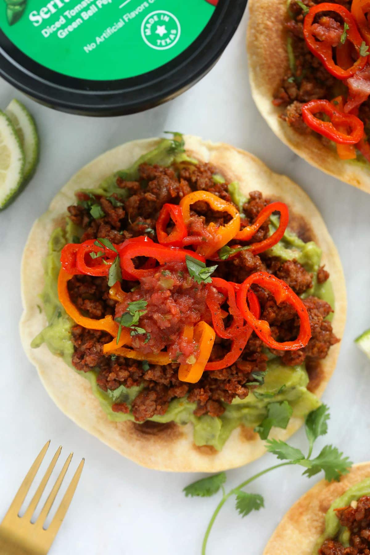 tostada with guacamole, plant based ground, peppers, and salsa