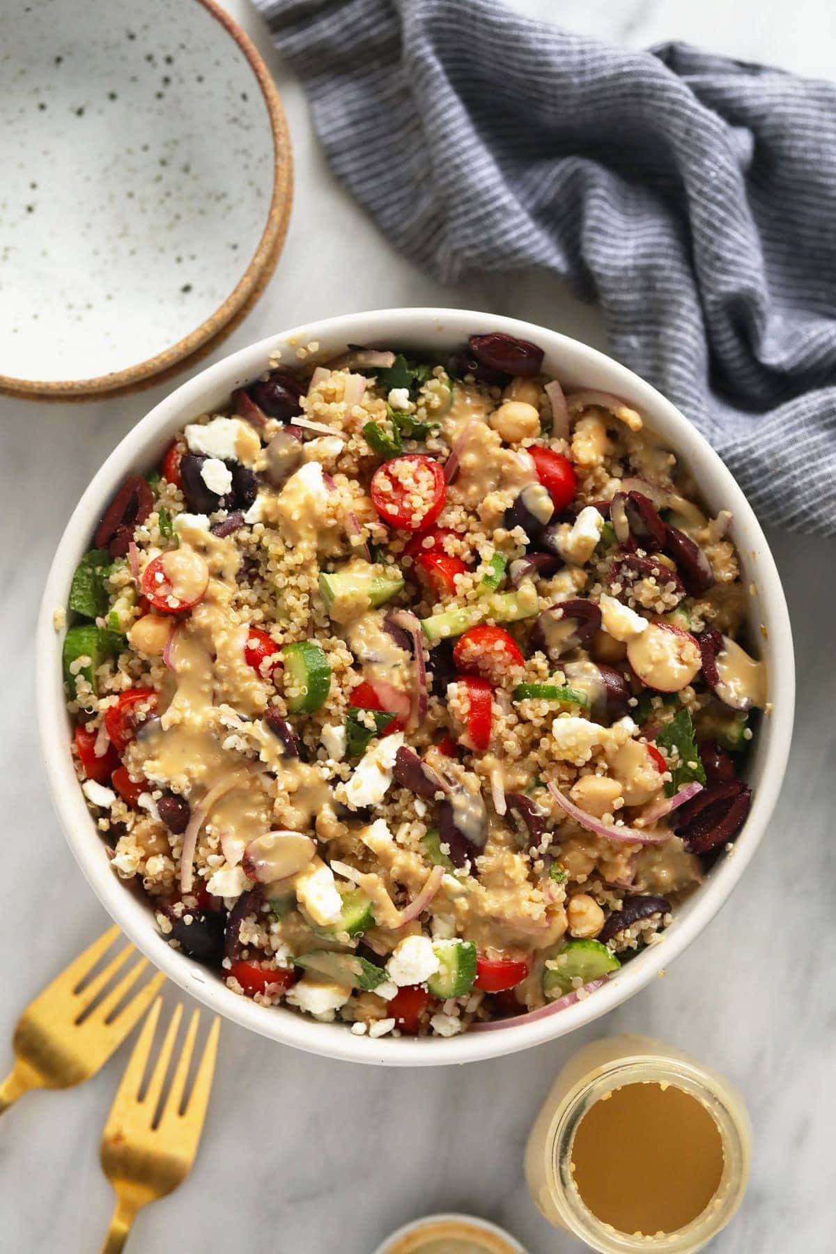 quinoa salad in bowl with hummus dressing.