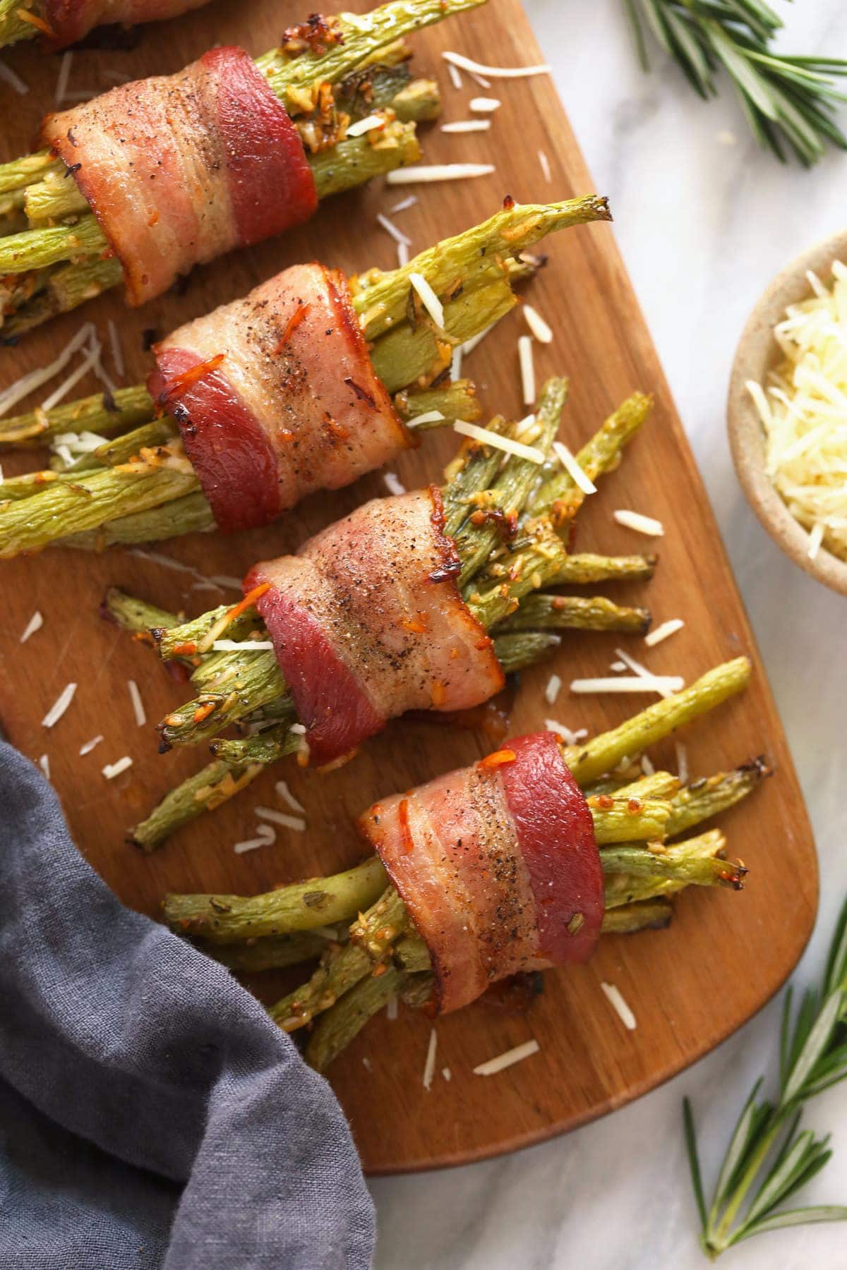 bacon wrapped green beans served on a wooden platter