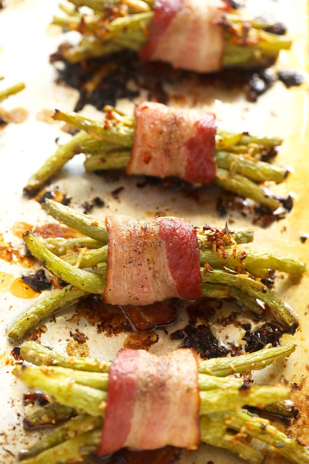 bacon wrapped green beans on a baking sheet