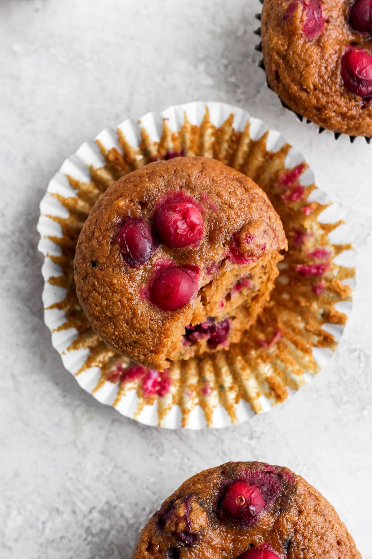 cranberry orange muffin in a muffin liner