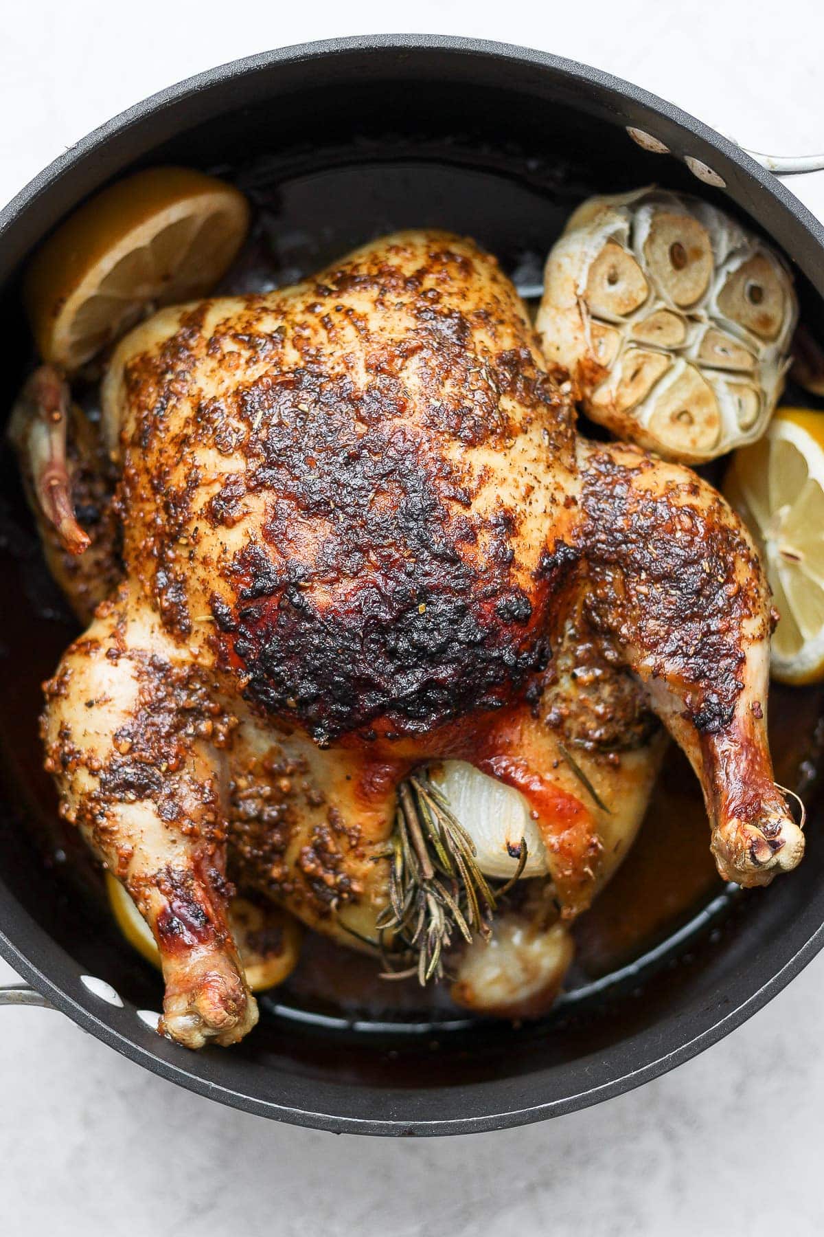 whole roasted chicken with garlic in pan