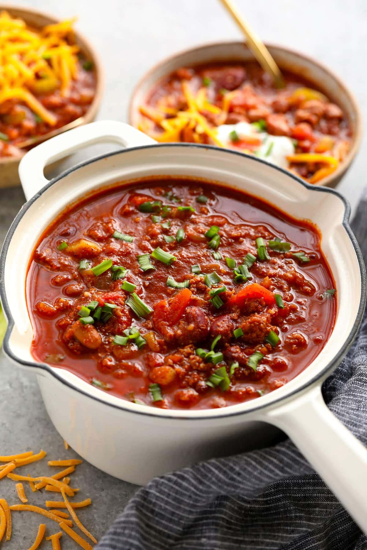 Turkey chili topped with green onions in a pot.