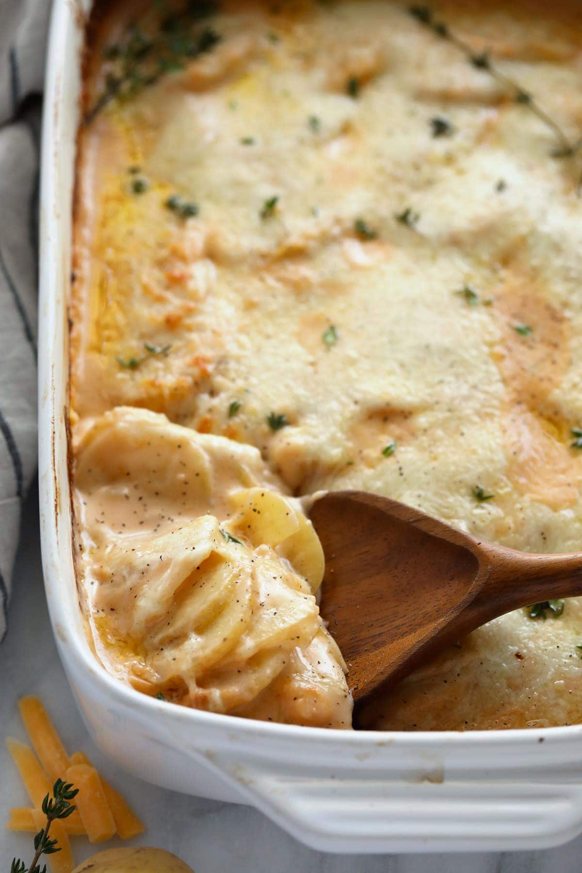 Cheesy scalloped potatoes in a casserole dish. 