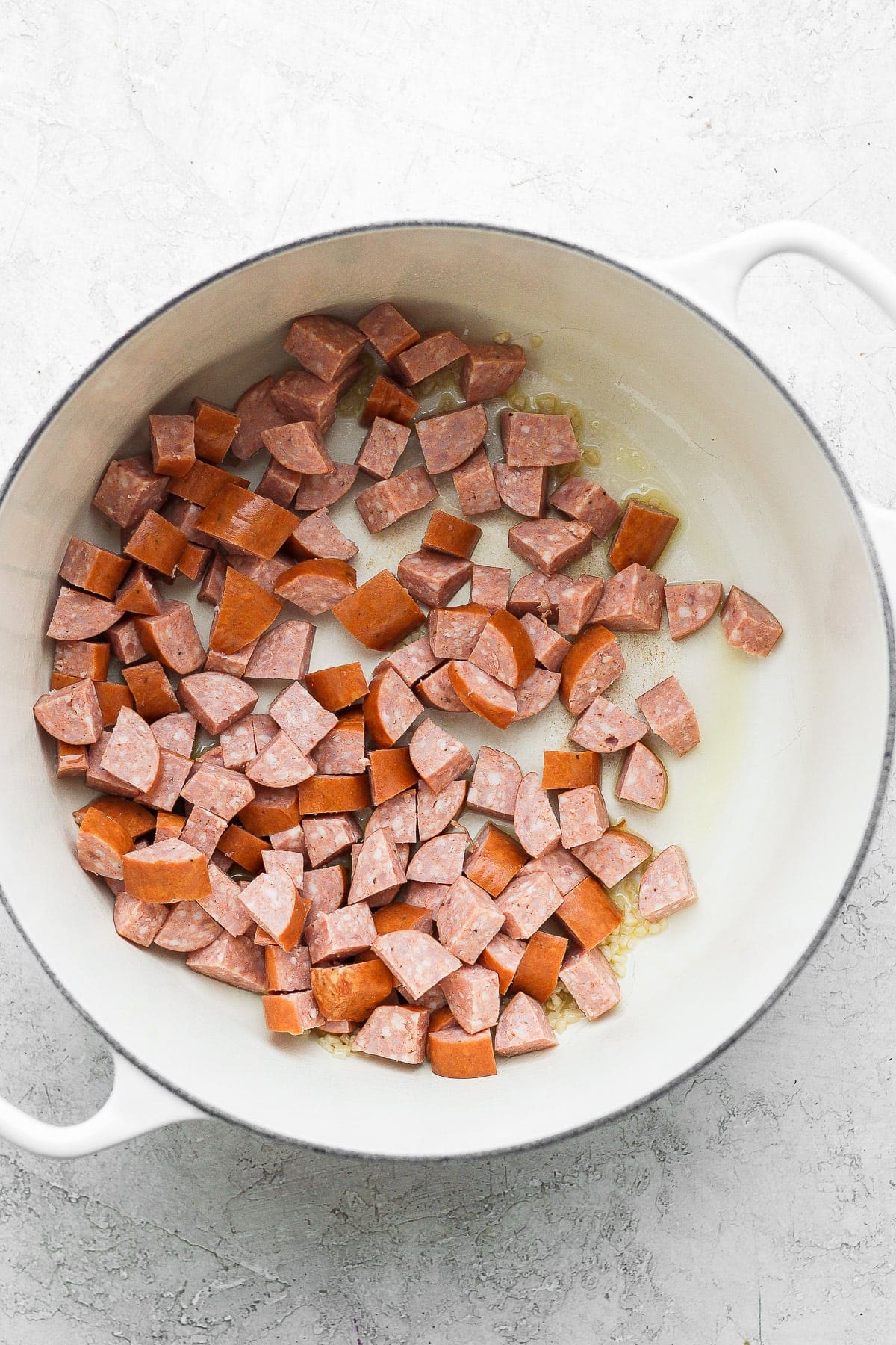 andouille sausage in a dutch oven, ready to be sautéed 