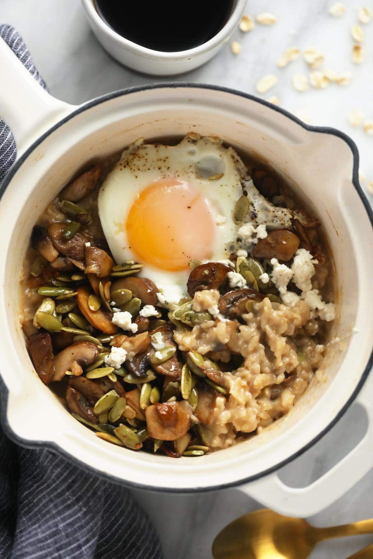 Savory oatmeal in a pot topped with an egg. 