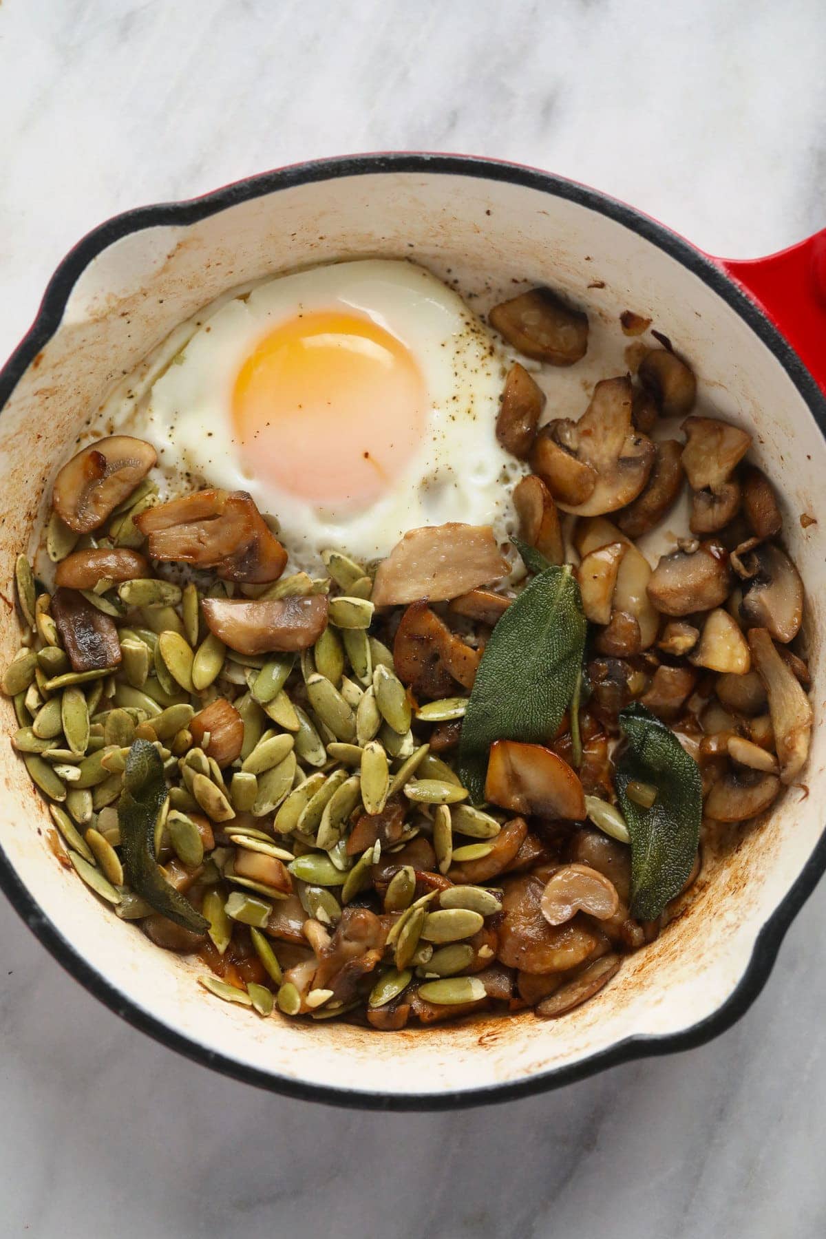 Savory oatmeal in a small pot with savory toppings, including an egg. 