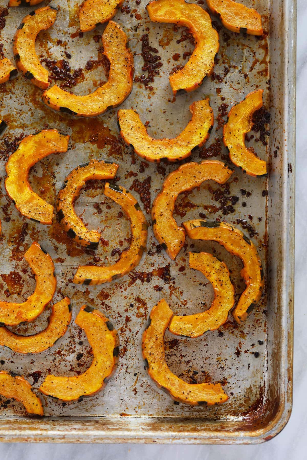 roasted delicata squash on a roasting pan