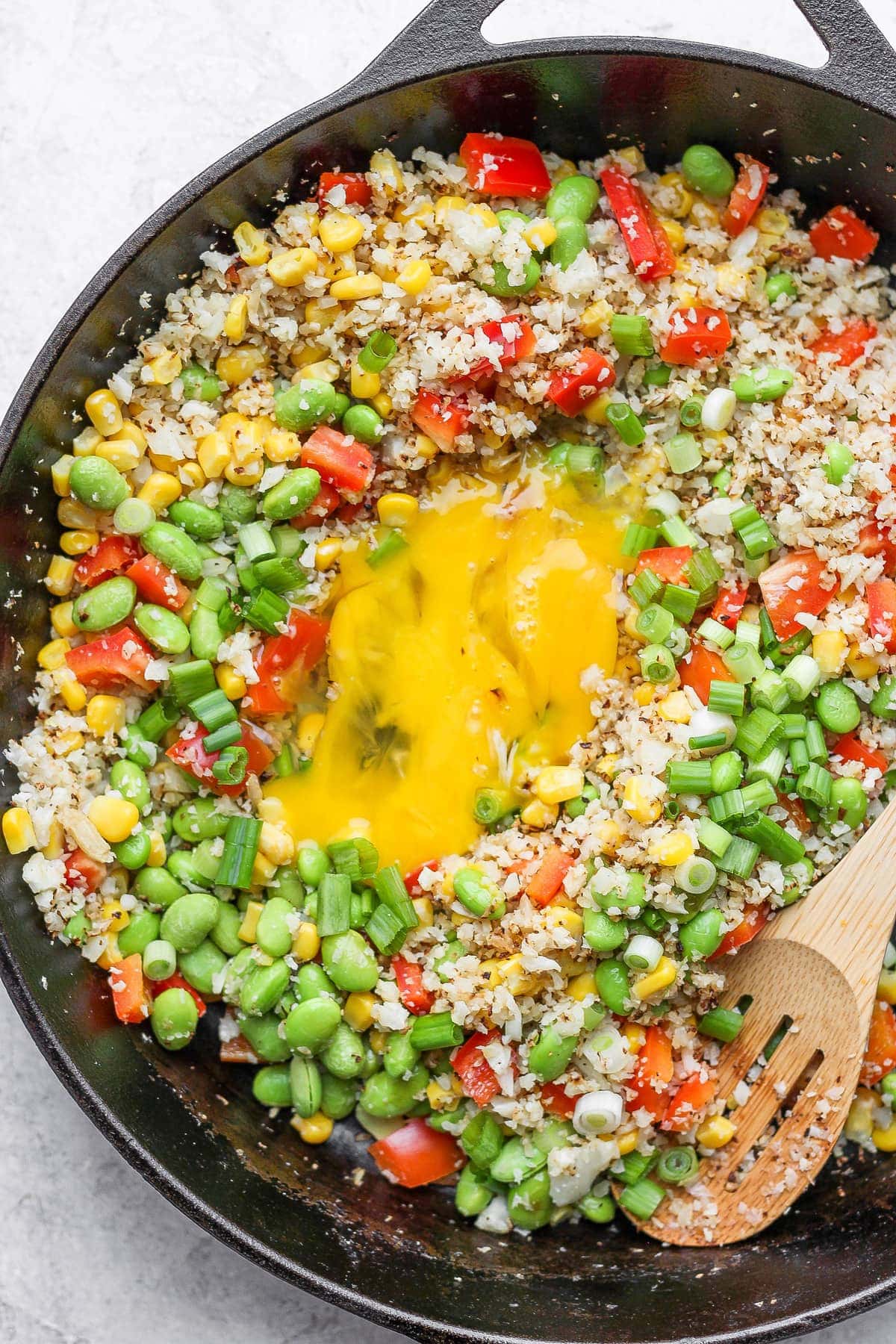 cauliflower fried rice with eggs scrambled in the middle of the skillet