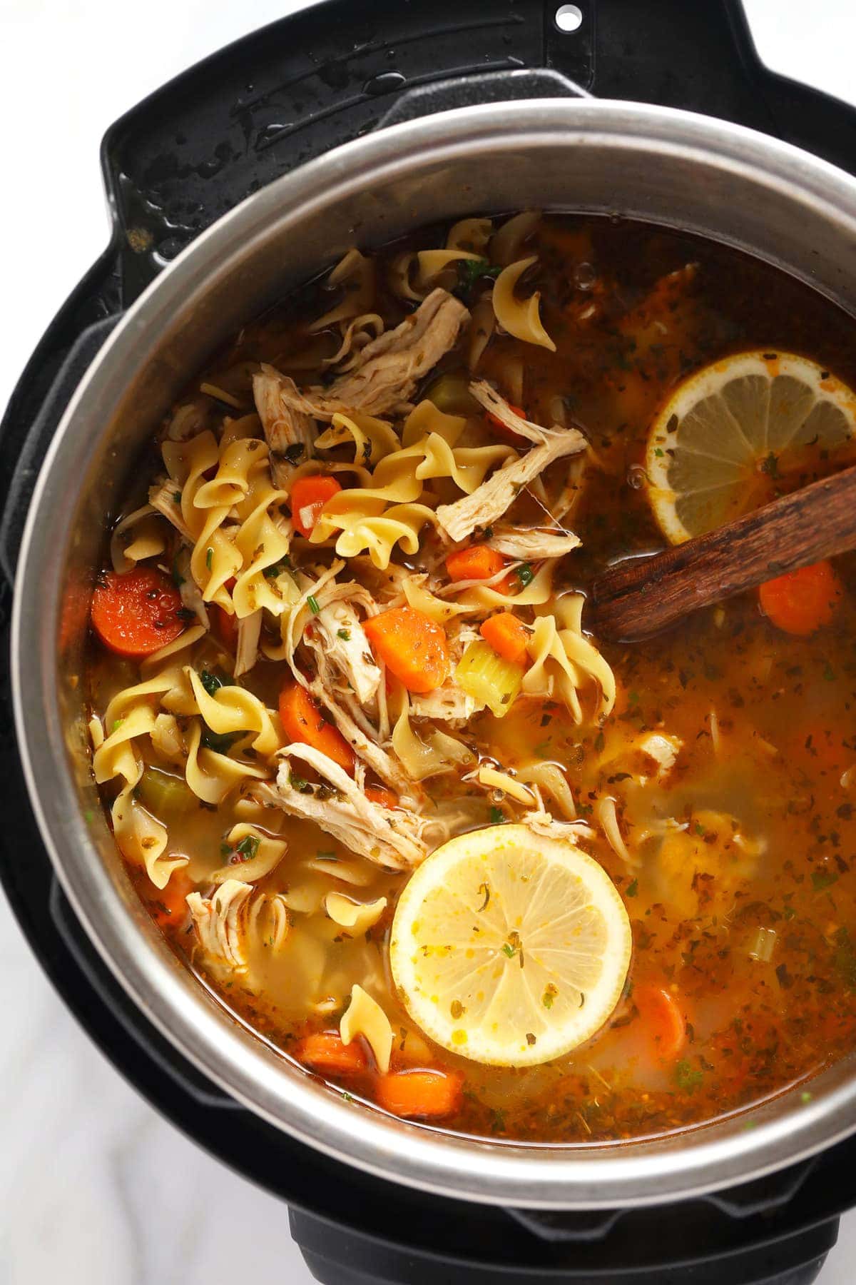 Instant Pot chicken noodle soup in IP with lemon wedge