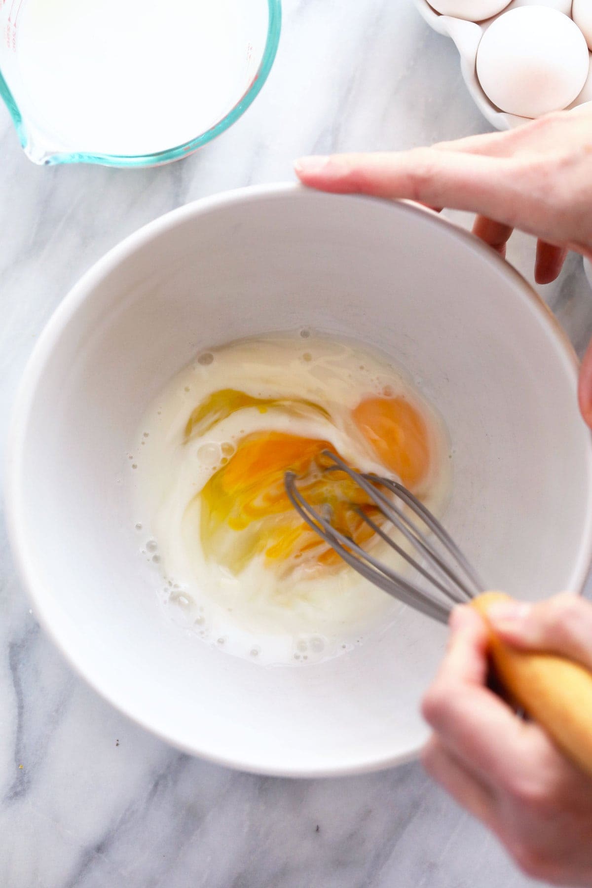 raw eggs and milk in a bowl ready to be mixed together for scrambled eggs