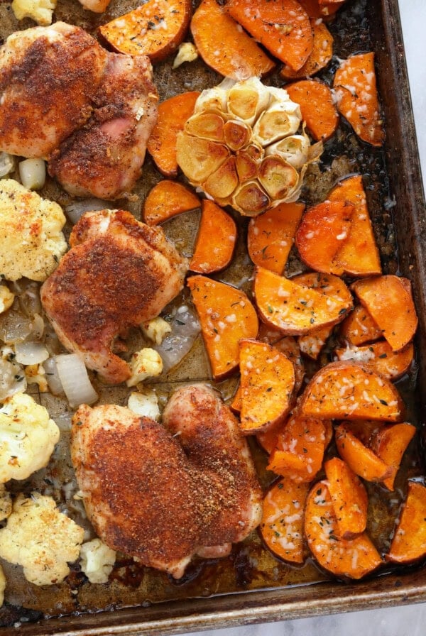 Chicken and veggies on a baking sheet.