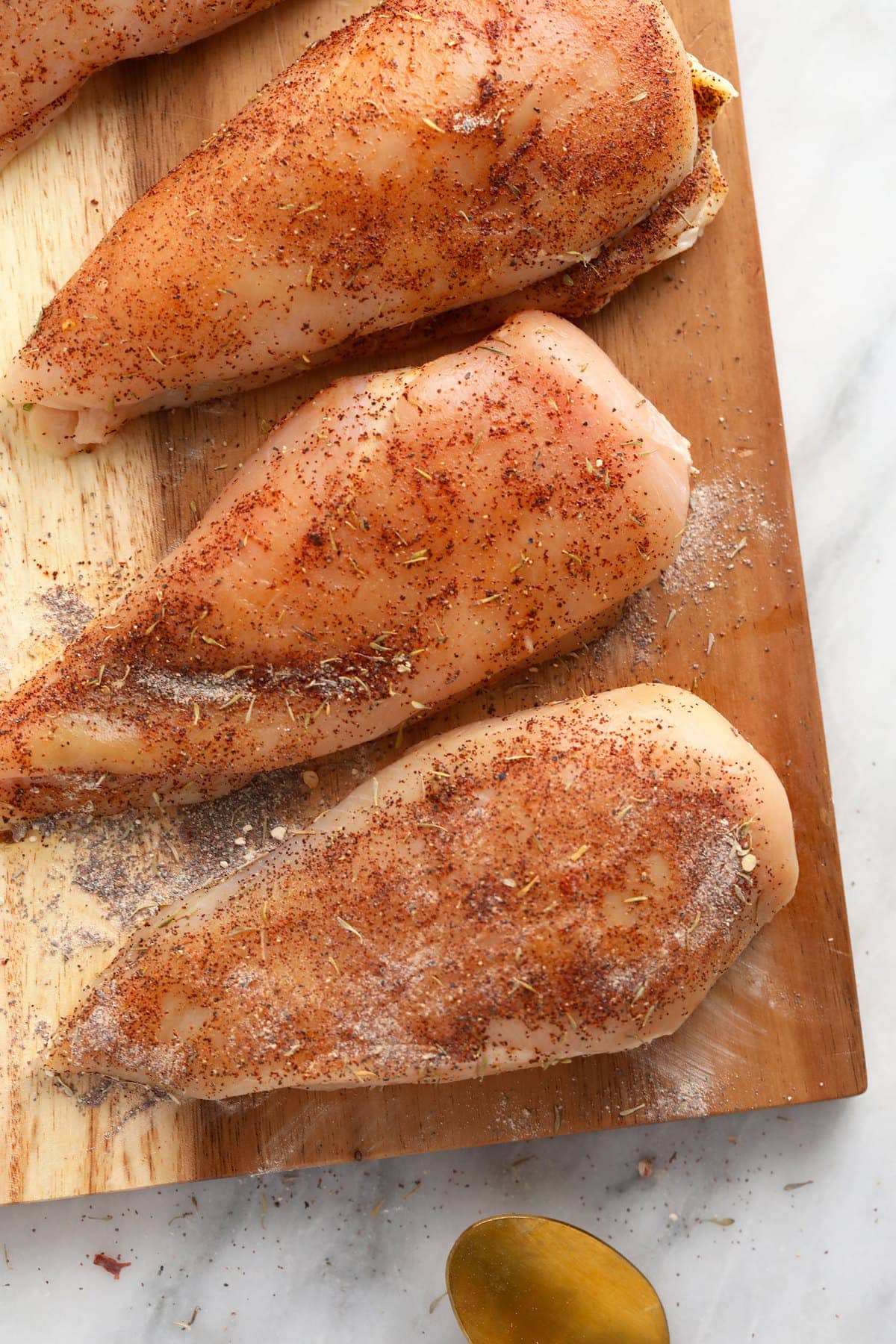 raw chicken breasts on a cutting board.