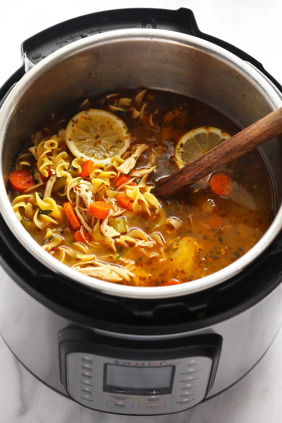 Instant Pot chicken Noodle Soup in Instant Pot with wooden spoon