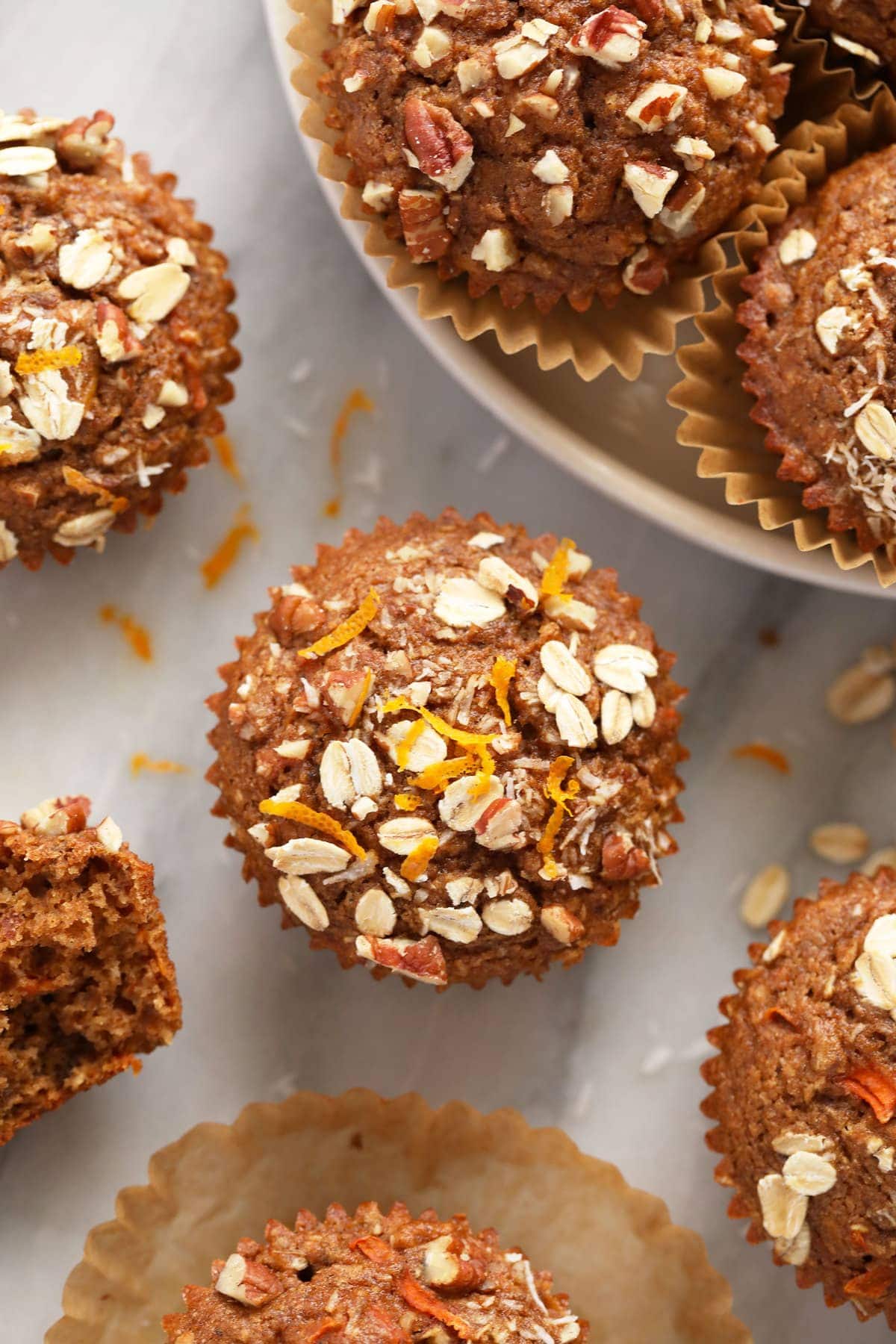 A morning glory muffin with fresh orange zest on top of the muffin. 