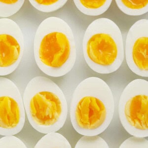 A group of hard boiled eggs on a white surface.