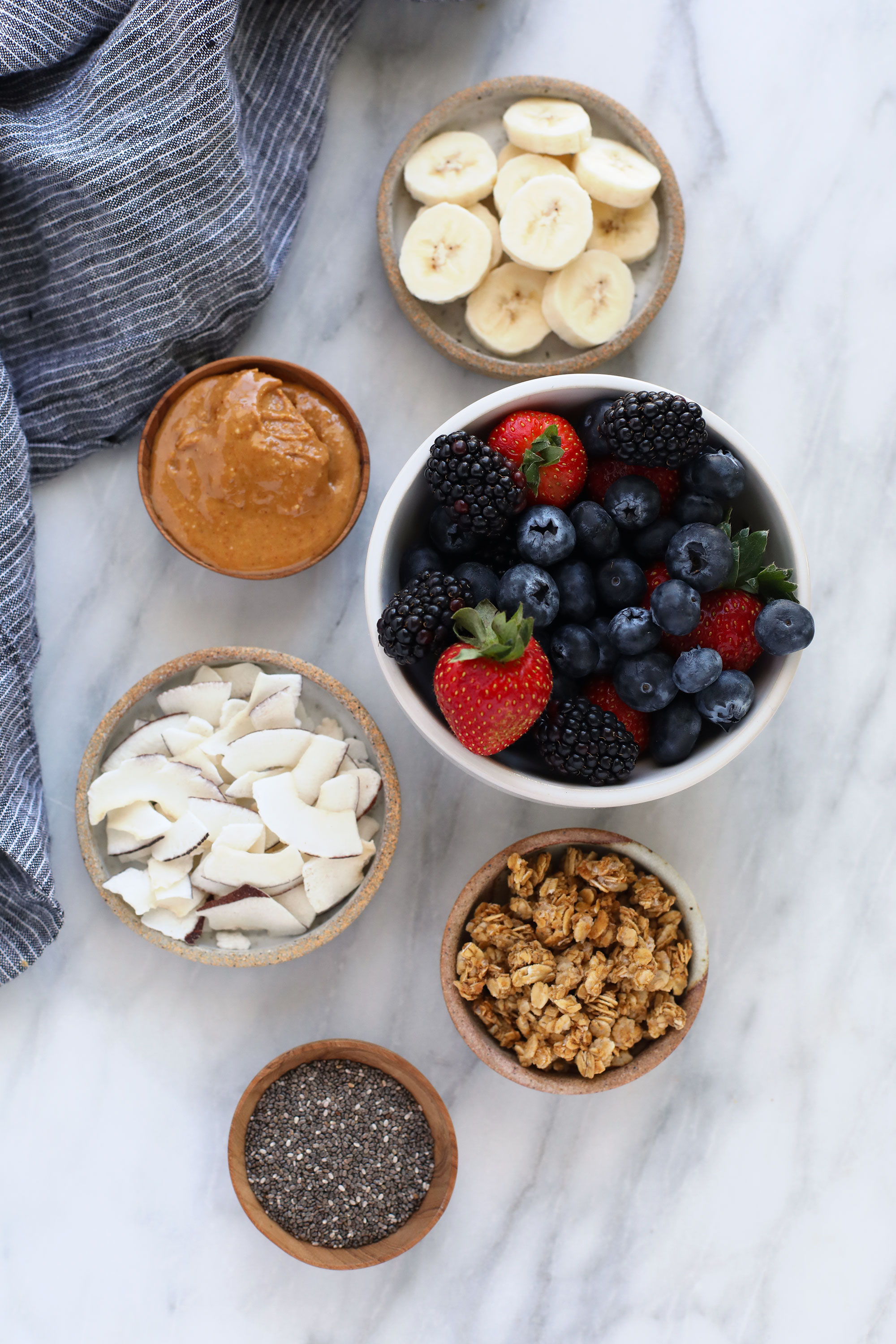 berries, peanut butter, coconut, granola, chia seeds, and banana slices