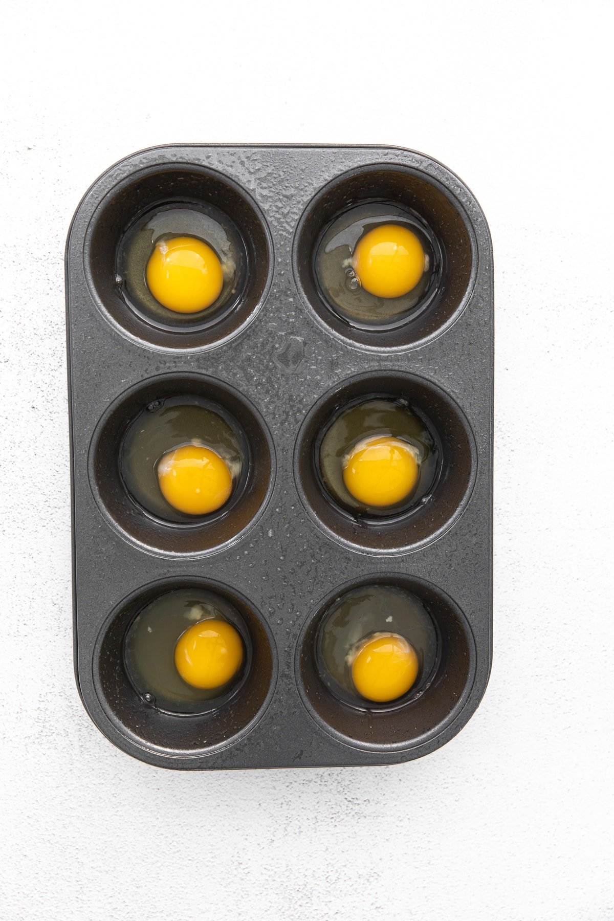 raw eggs in muffin tin