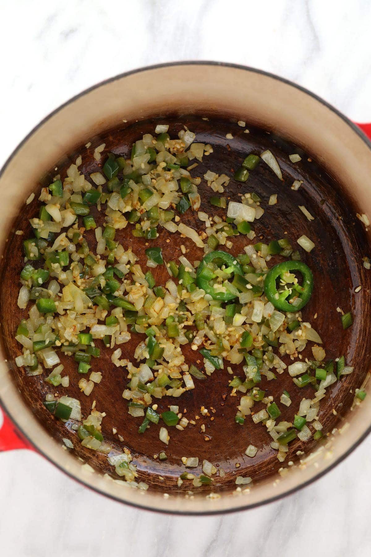 jalapeños, onions and garlic sautéing in a dutch oven