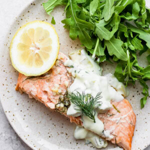 salmon on a plate with tartar sauce.