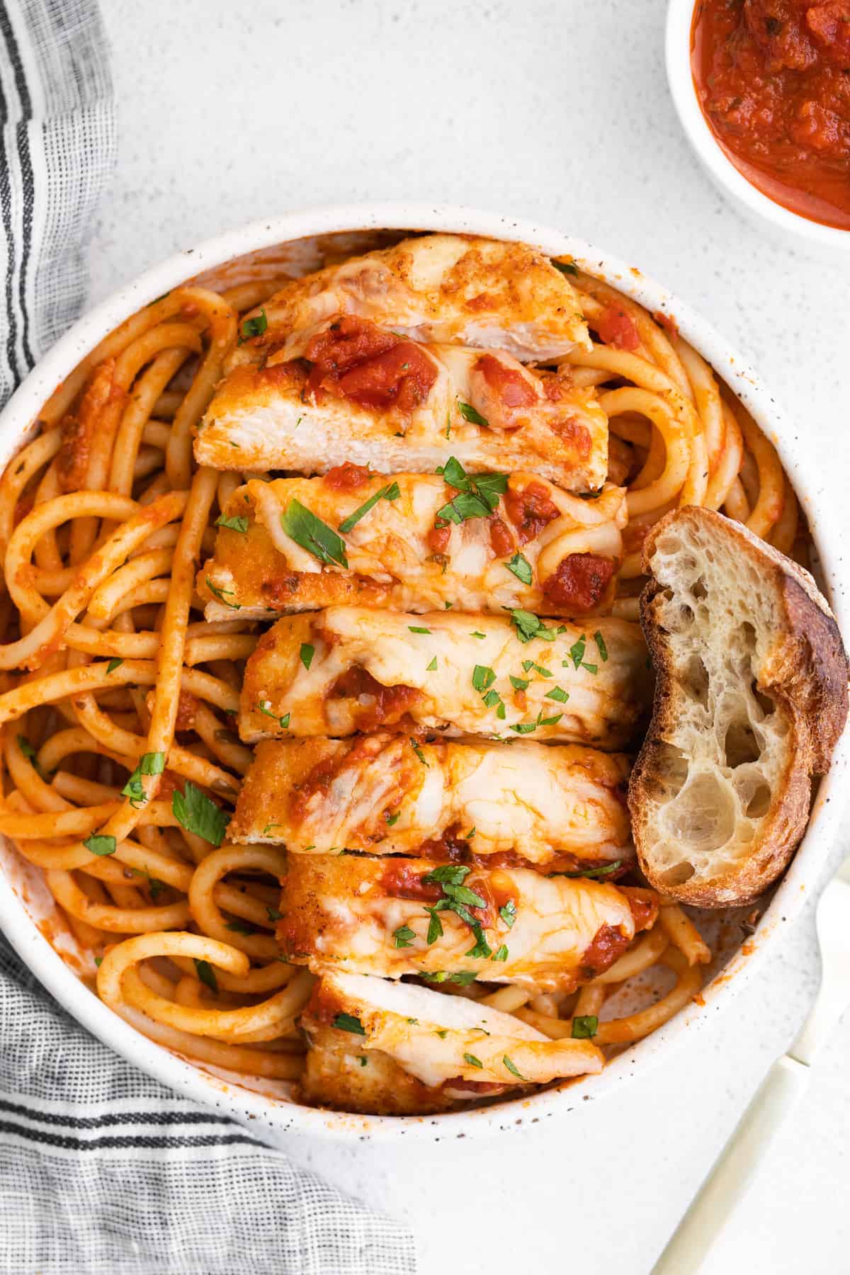 sliced chicken parmesan on noodles