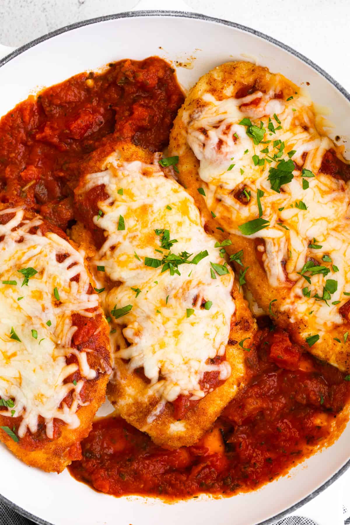 chicken parmesan with cheese and basil on noodles.